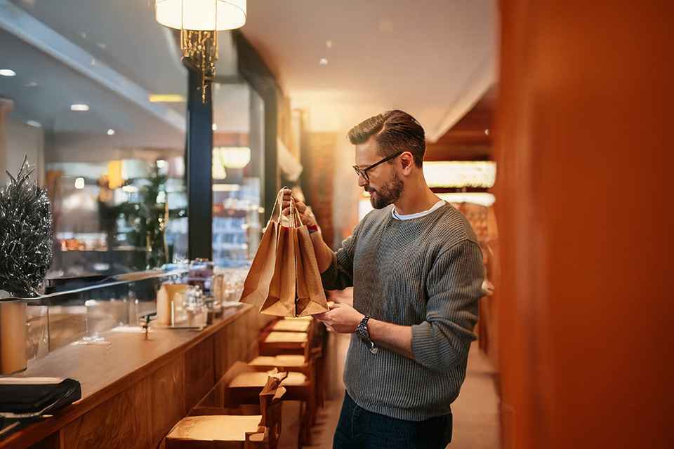 Foto: Mann mit Papiertüten